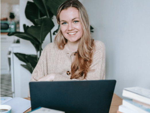 woman smiling sitting with labtop in office