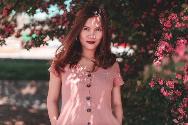 woman smiling under flowering tree 